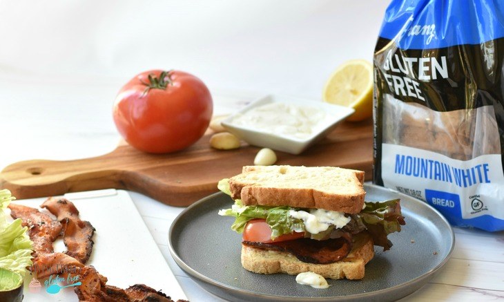 BLT Sandwich on a plate with fixings and bread nearby