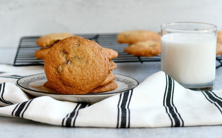 gluten free chocolate chip cookies on a plate with a towel and cup of milk 