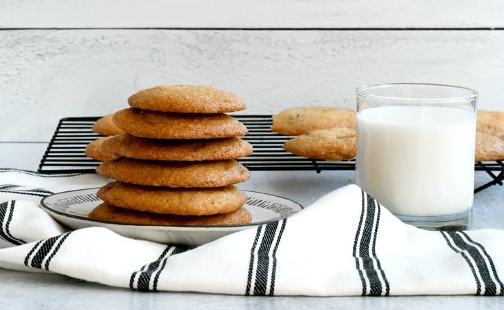 Gluten free cookies on a plate with a towel and a cup of milk 