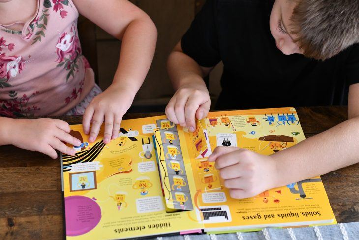 kids flipping through a bookshark science book 