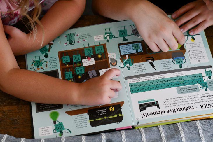 kids flipping through a bookshark science book 