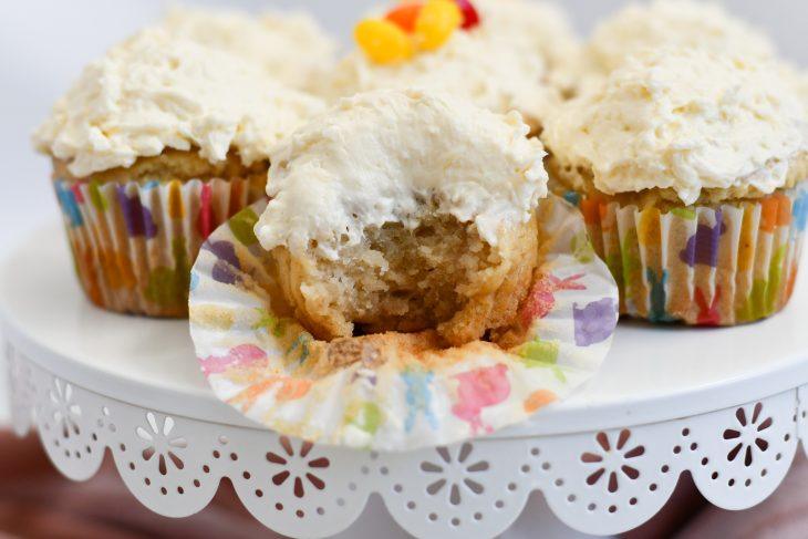 Easy gluten free coconut cupcakes on a plate, one cupcake has a bite taken out of it 