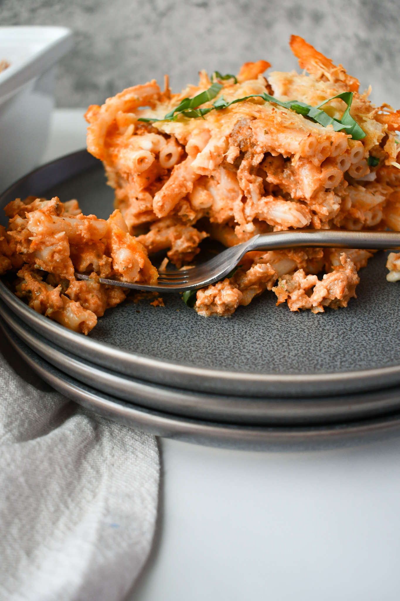 Delicious Gluten Free Sausage Pasta Bake in a casserole dish with gooey cheese and fresh herbs.