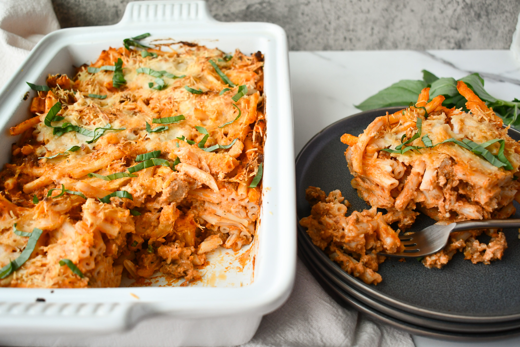 Delicious Gluten Free Sausage Pasta Bake in a casserole dish with gooey cheese and fresh herbs.