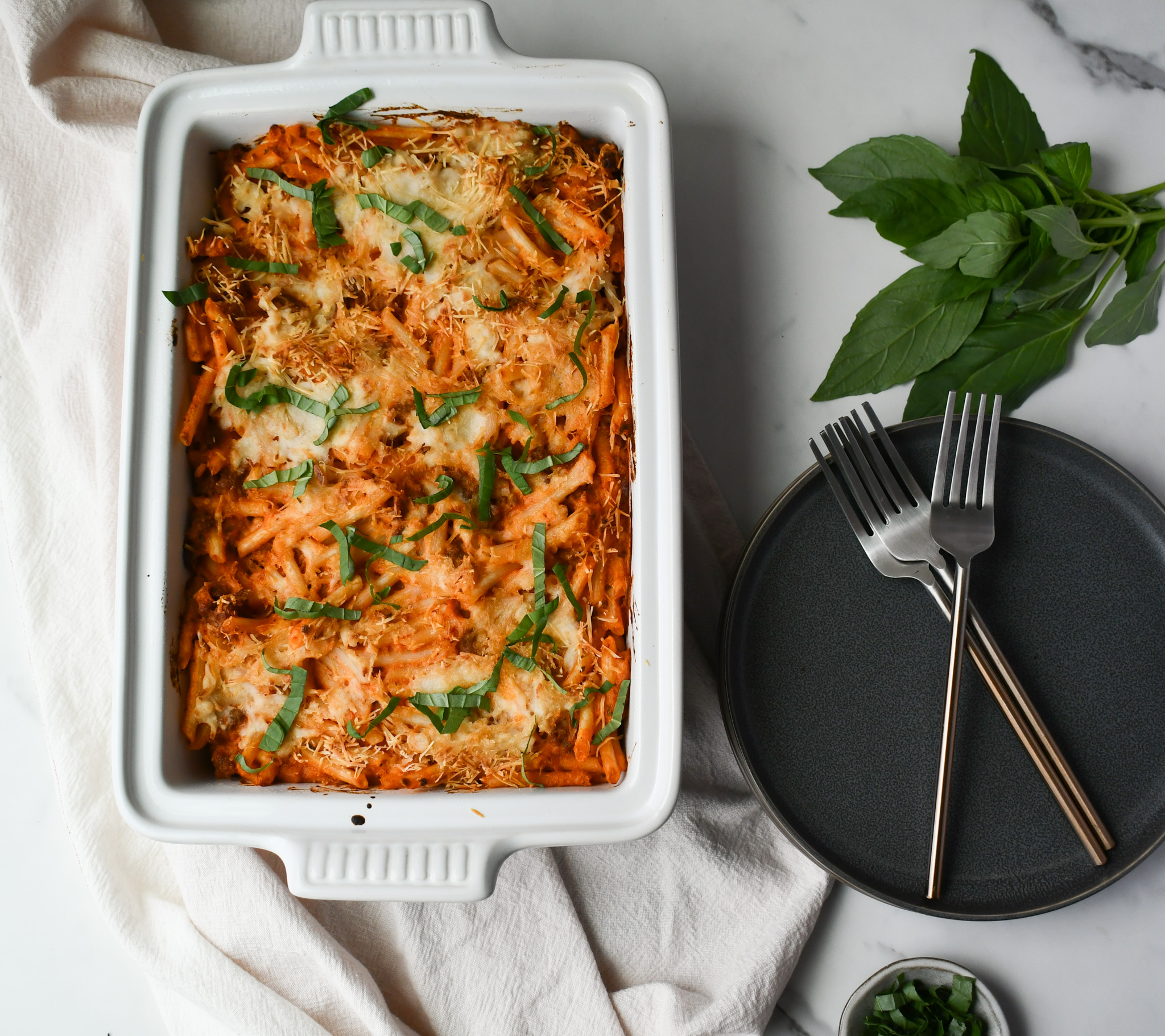 Delicious Gluten Free Sausage Pasta Bake in a casserole dish with gooey cheese and fresh herbs.
