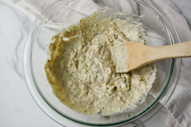 all of the cheesy ingredients blended together in a bowl. 