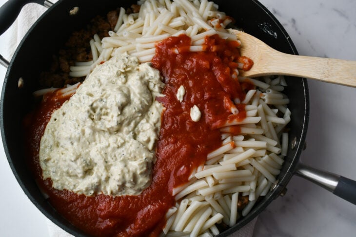 When the noodles are al dente, drain and rinse with cold water. In a large pot (you can use the one you cooked the meat or pasta in) combine the sausage, penne, creamy cheese mixture and marinara sauce.