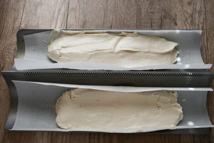 dough spread evenly into prepared baguette pan