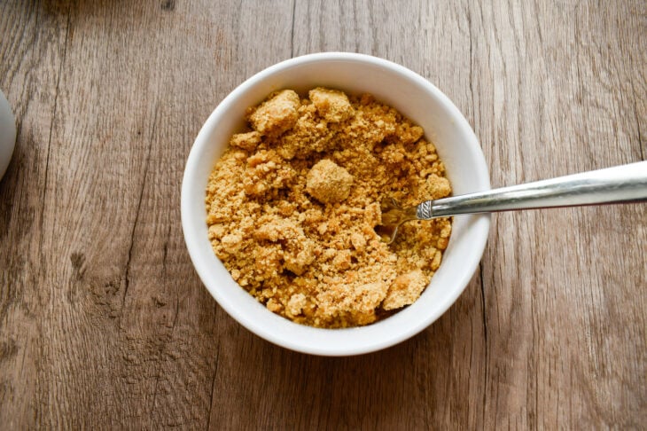 Step 2: In a bowl combine the gluten free graham cracker crumbs and melted coconut oil.