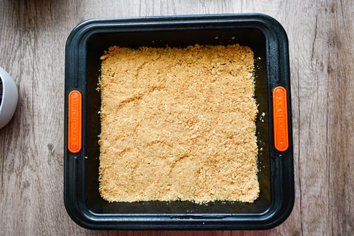  Press the crumb mixture firmly into the bottom of the baking dish to form the crust.